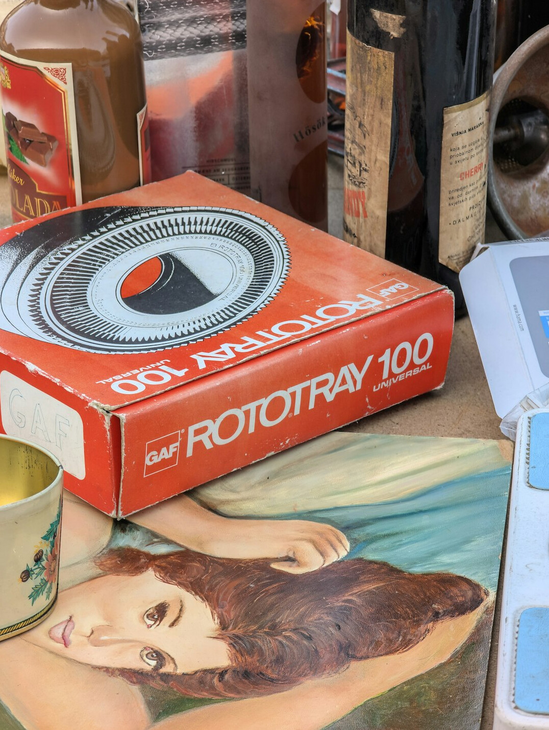 Stack of vintage advertising film reels beside a boxy 1980s television