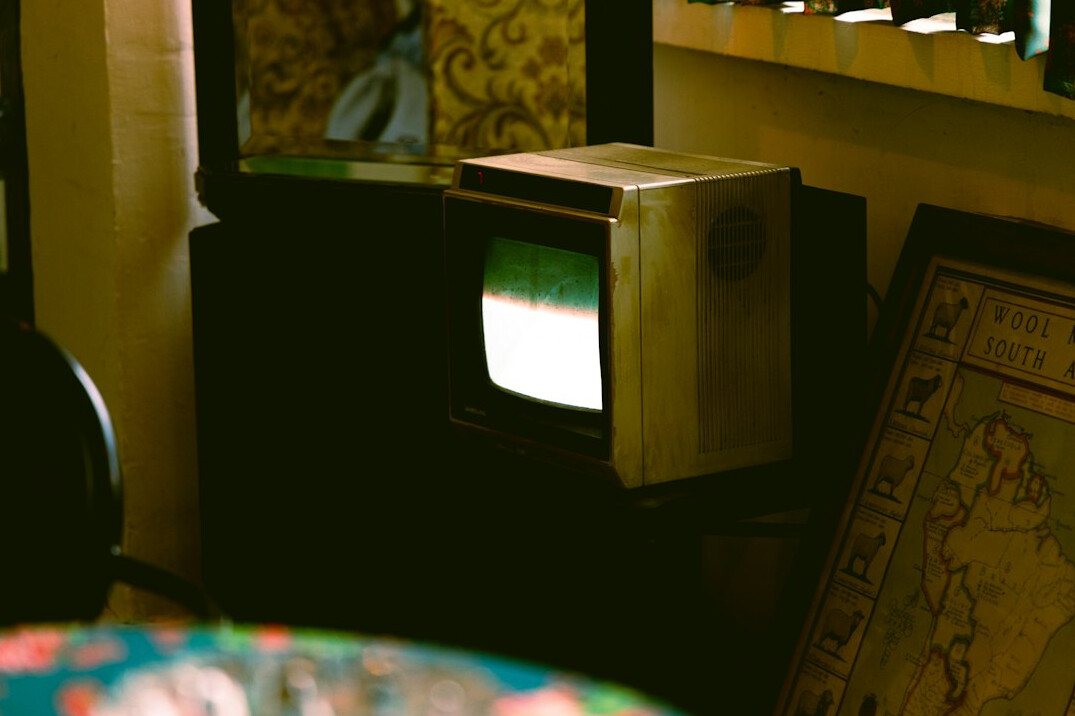 Vintage television screen next to stacked retro advertising posters